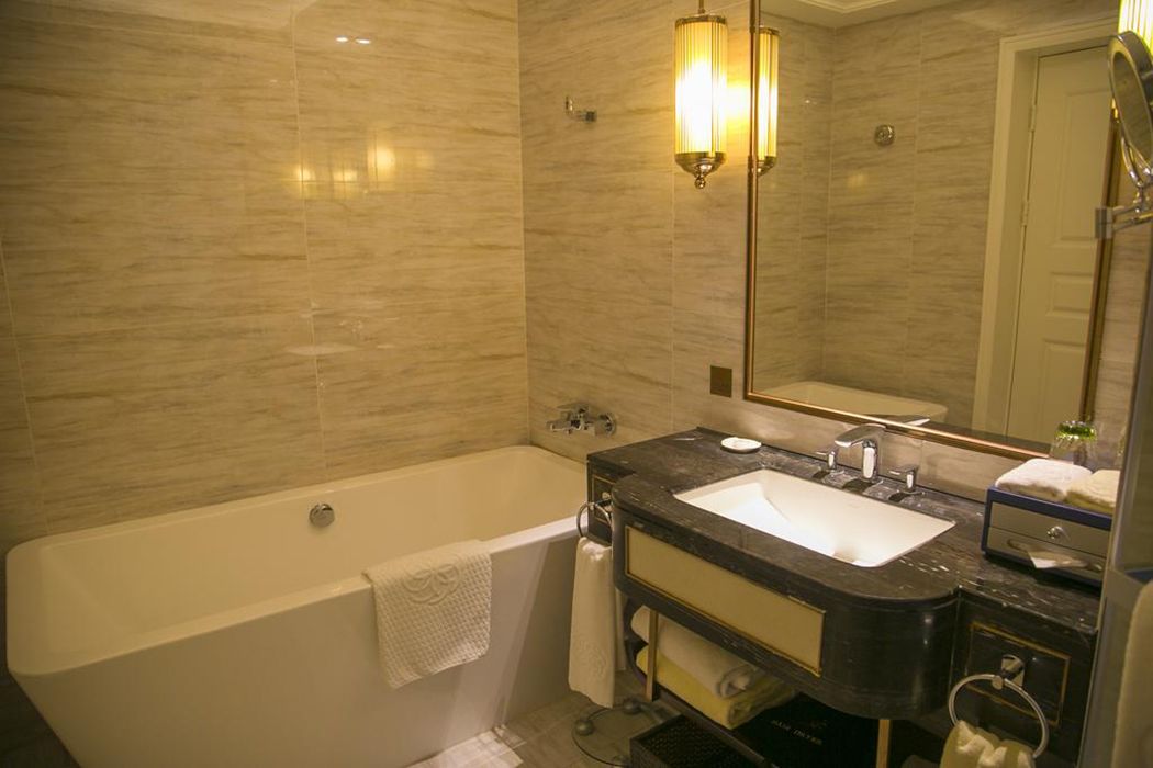 A modern bathroom with a bathtub, a sink, and a large mirror.