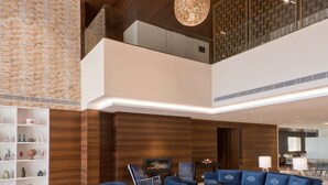 A spacious lobby with a high ceiling, blue sofas, a patterned rug, and hanging spherical light fixtures. - Country Inn & Suites by Radisson Zirakpur (Dera Bassi)