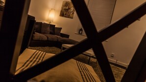 A living room with a sofa, a lamp, and a wall-mounted picture frame. - Station Suite - Simple2let Serviced Apartments (Halifax)