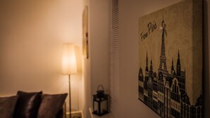 A room with a lamp, a small table, and a wall-mounted artwork depicting Parisian architecture. - Station Suite - Simple2let Serviced Apartments (Halifax)