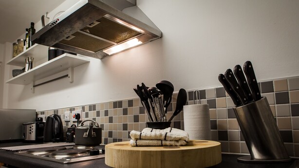 A kitchen with a stove, kettle, and various utensils on the counter. - Central Suite - Simple2let Serviced Apartments (Halifax)
