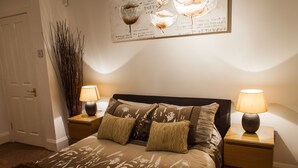 A bedroom with a bed, two bedside tables, and a wall-mounted artwork. - Central Suite - Simple2let Serviced Apartments (Halifax)