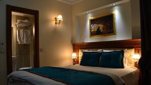 Ein Hotelzimmer mit einem großen Bett, zwei Wandleuchten, einem Bild über dem Bett und einem Badezimmer mit Handtuchhalter.