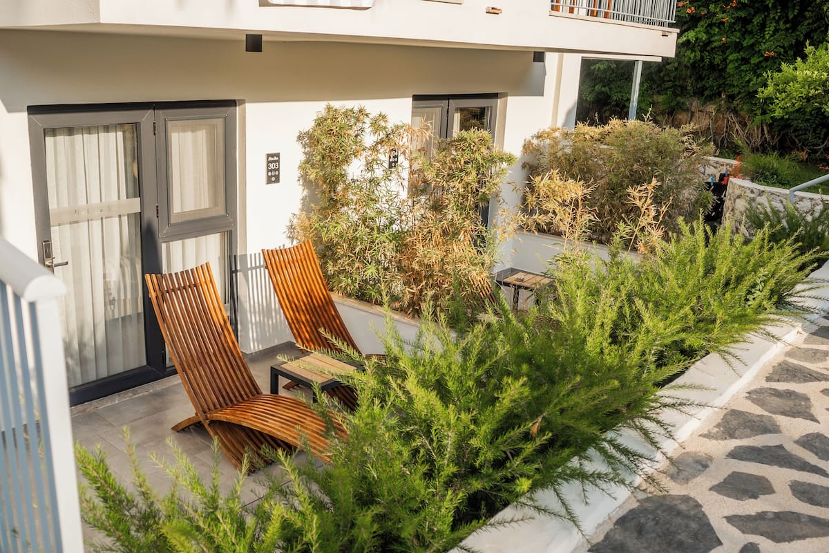 A modern building with a covered outdoor seating area, a staircase, and a gate.