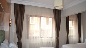 A hotel room with two beds, sheer curtains, and a large window. - Istanbul Comfort Hotel (Istanbul)