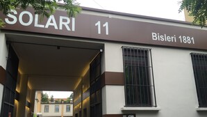 L’entrée d’un immeuble, avec une enseigne indiquant « SOLARI 11 » et « Bişleri 1881 ».