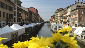 Ein Kanal, gesäumt von Gebäuden, mit weißen Zelten und gelben Blumen im Vordergrund.