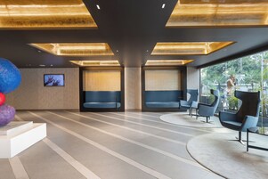 Un vestíbulo moderno con zona de estar, una escalera y vistas al exterior.