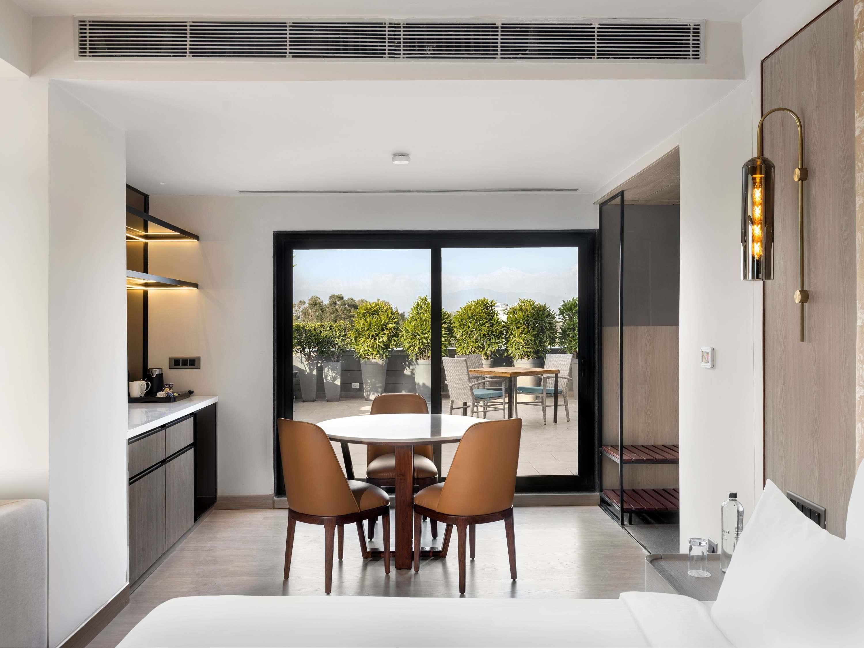 Una cocina moderna con comedor, un amplio ventanal corredero al exterior y un calefactor empotrado.