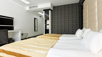 Una habitación de hotel con dos camas, un escritorio, una silla y un armario.