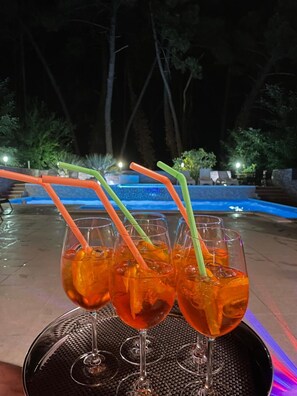 Una zona piscina con un tavolo su cui ci sono quattro bicchieri con cannucce.