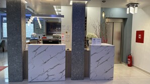 A reception area with marble counters, a coffee machine, and a fire extinguisher.