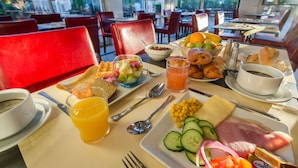 Een ontbijtsetting met diverse producten, zoals fruit, brood en een bord met gesneden groenten.