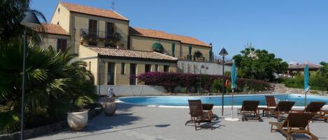 Een seizoensgebonden buitenzwembad en parasols bij het zwembad