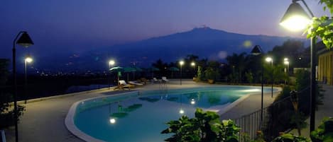 Una piscina al aire libre de temporada, sombrillas