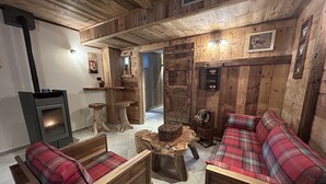 Un interior rústico con muebles de madera, chimenea y un rincón de descanso acogedor.