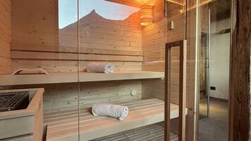 Ein Holz-Saunaraum mit Bänken und einer Glasscheibe.