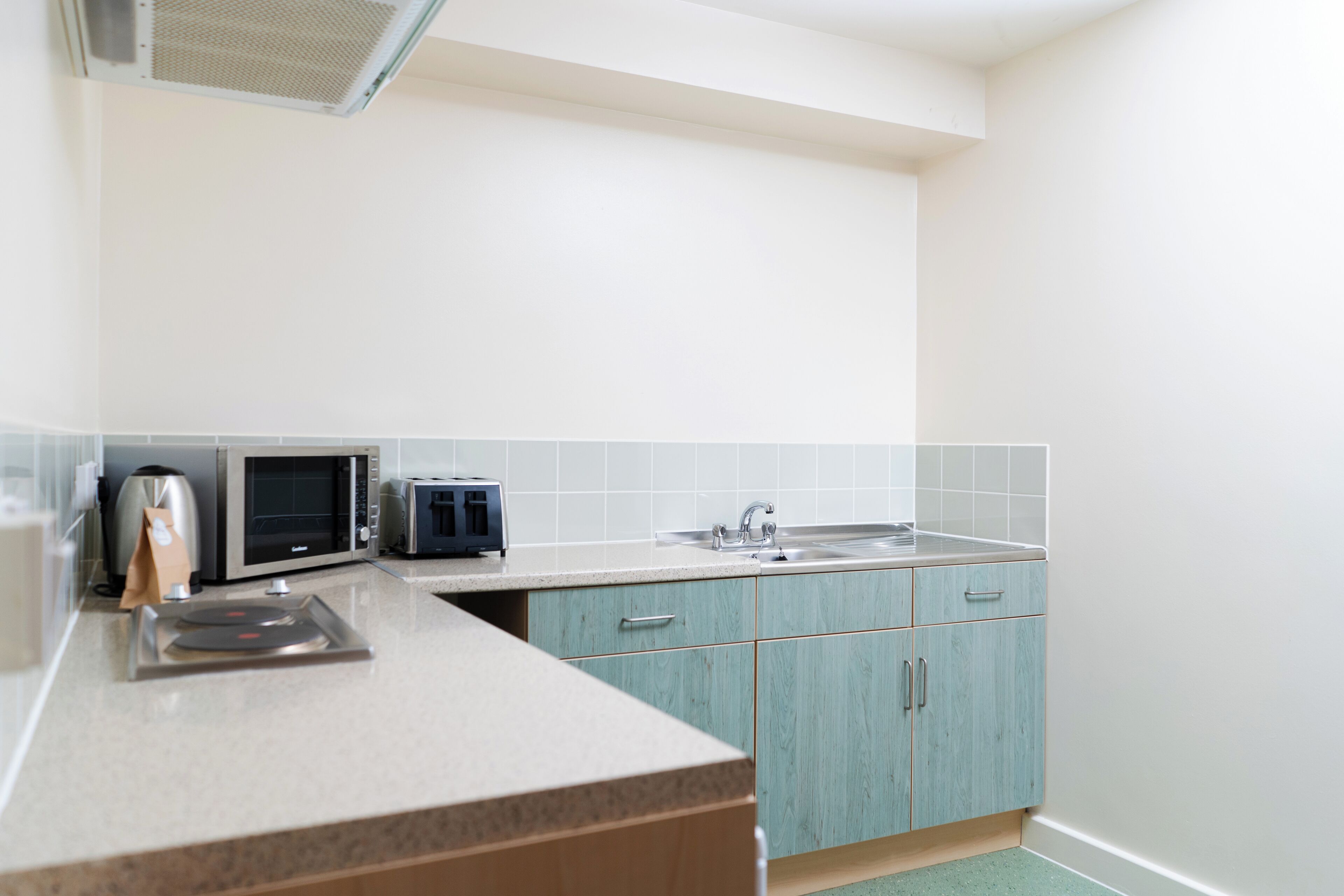 A kitchen with a microwave, toaster, and sink.
