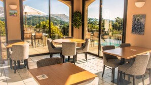 A dining area with a view of mountains and a pool. - Hôtel Le Panoramic (La Palud-sur-Verdon)