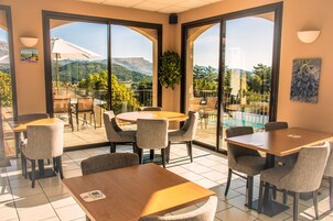 Uma área de refeições com vista para montanhas e uma piscina.
