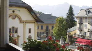 Un bâtiment sur lequel on peut lire l’inscription « JARDIN PUBLIC », avec une vue sur des montagnes en arrière-plan.