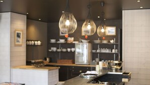 Une cuisine moderne dotée de luminaires suspendus, d’un îlot central et d’appareils électroménagers en acier inoxydable.