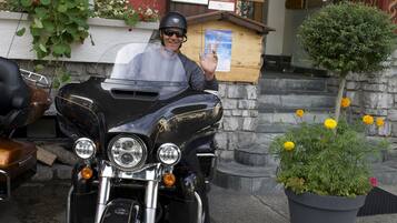 A motorcycle parked in front of a hotel with a sign reading "HOTEL VAL D'EST".