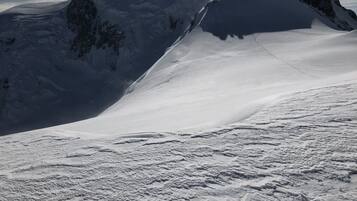 Montanha coberta de neve com céu claro e luz do sol.