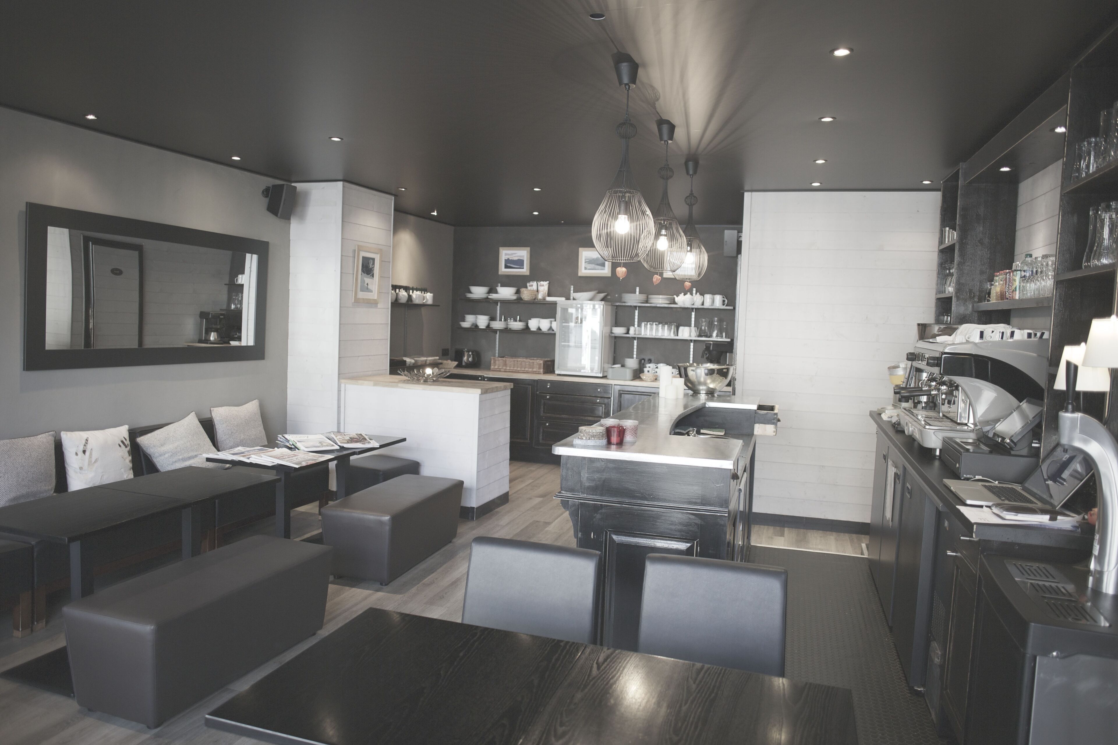A modern kitchen with a central island, built-in appliances, and a dining area with a bench and table.