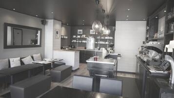 A modern kitchen with a central island, built-in appliances, and a dining area with a bench and table.