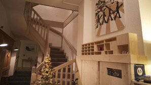 Un escalier avec une rampe en bois, un sapin de Noël et un panneau indiquant la catégorie de l’hôtel.