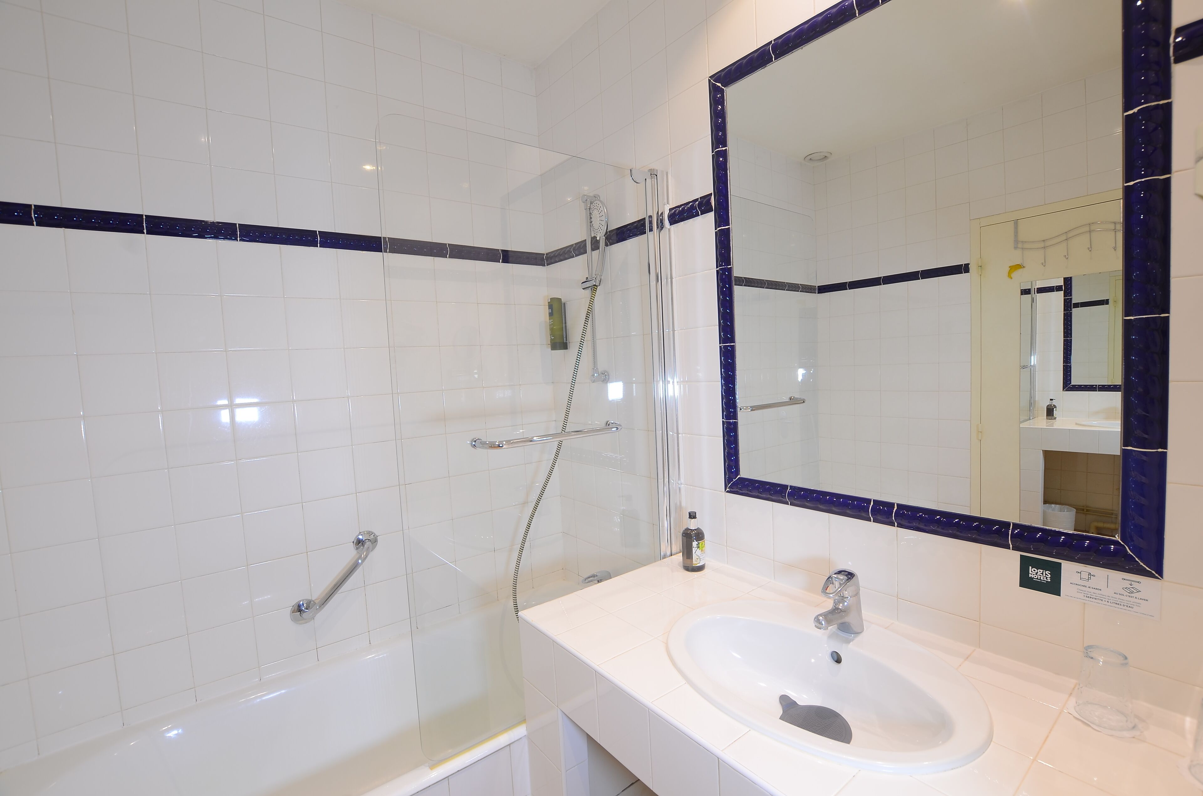 Une salle de bain équipée d’une baignoire, d’un lavabo et d’une douche avec une porte en verre.