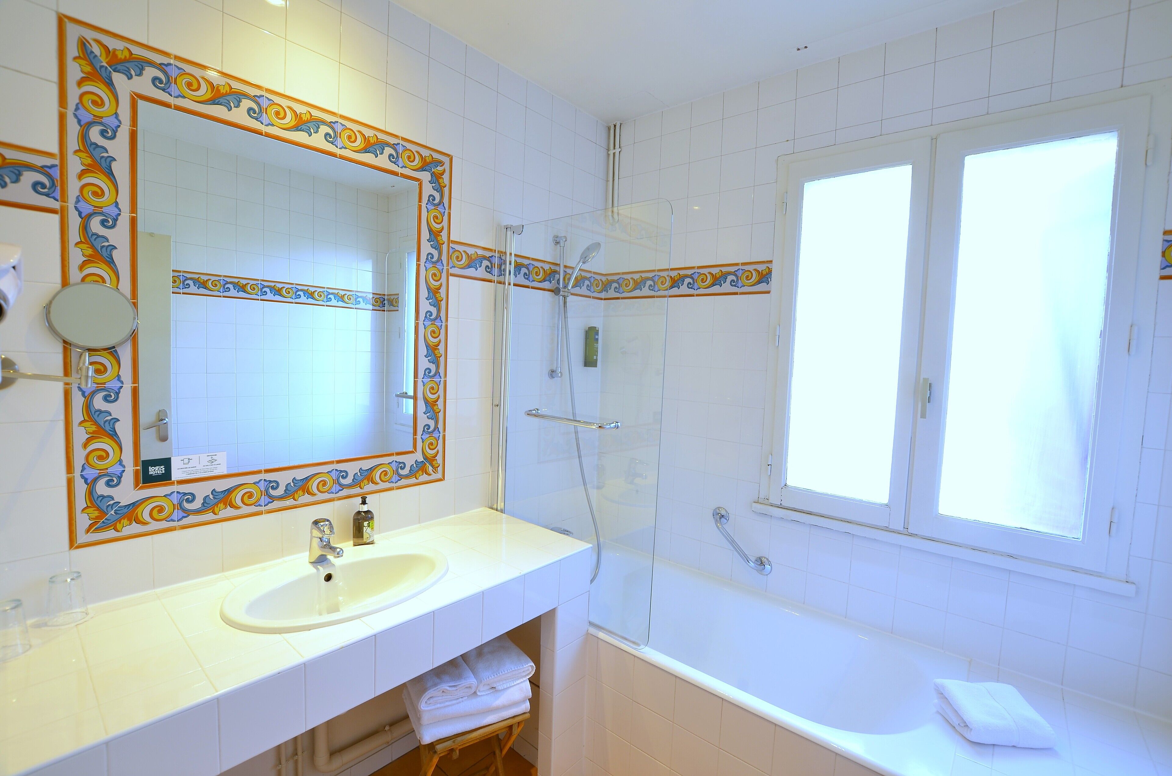 A bathroom with a white sink, mirror, and shower area.