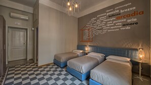 A hotel room with three beds, a checkered floor, and a word cloud on the wall. - The Pope's Window (Rome)