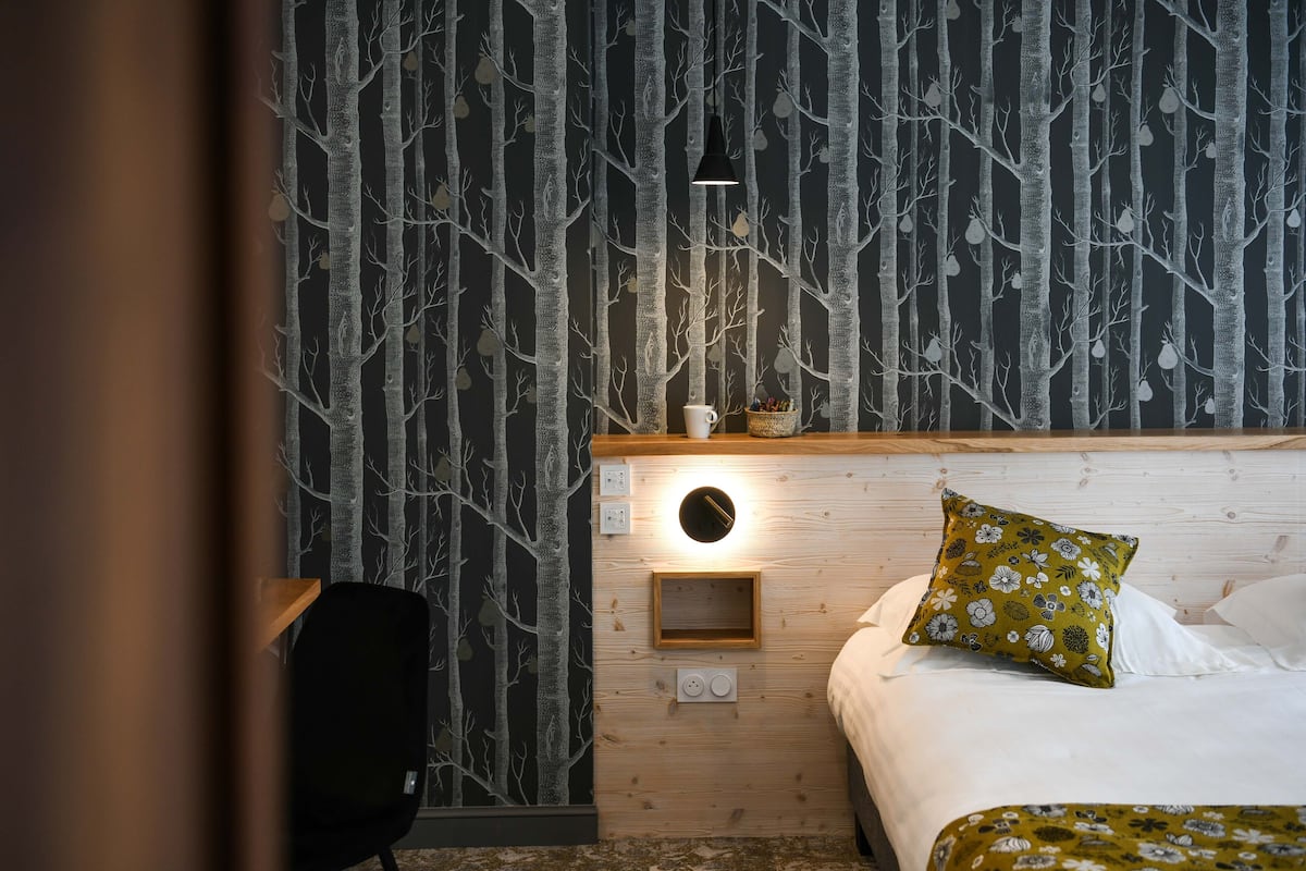 Une chambre à coucher avec un lit, une table de chevet, une lampe et une chaise.