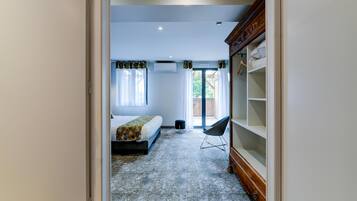 A bedroom with a bed, a chair, a wardrobe, and a window.