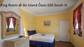 Una habitación tipo King en An Island Oasis, con una cama grande, cómoda y espejo.