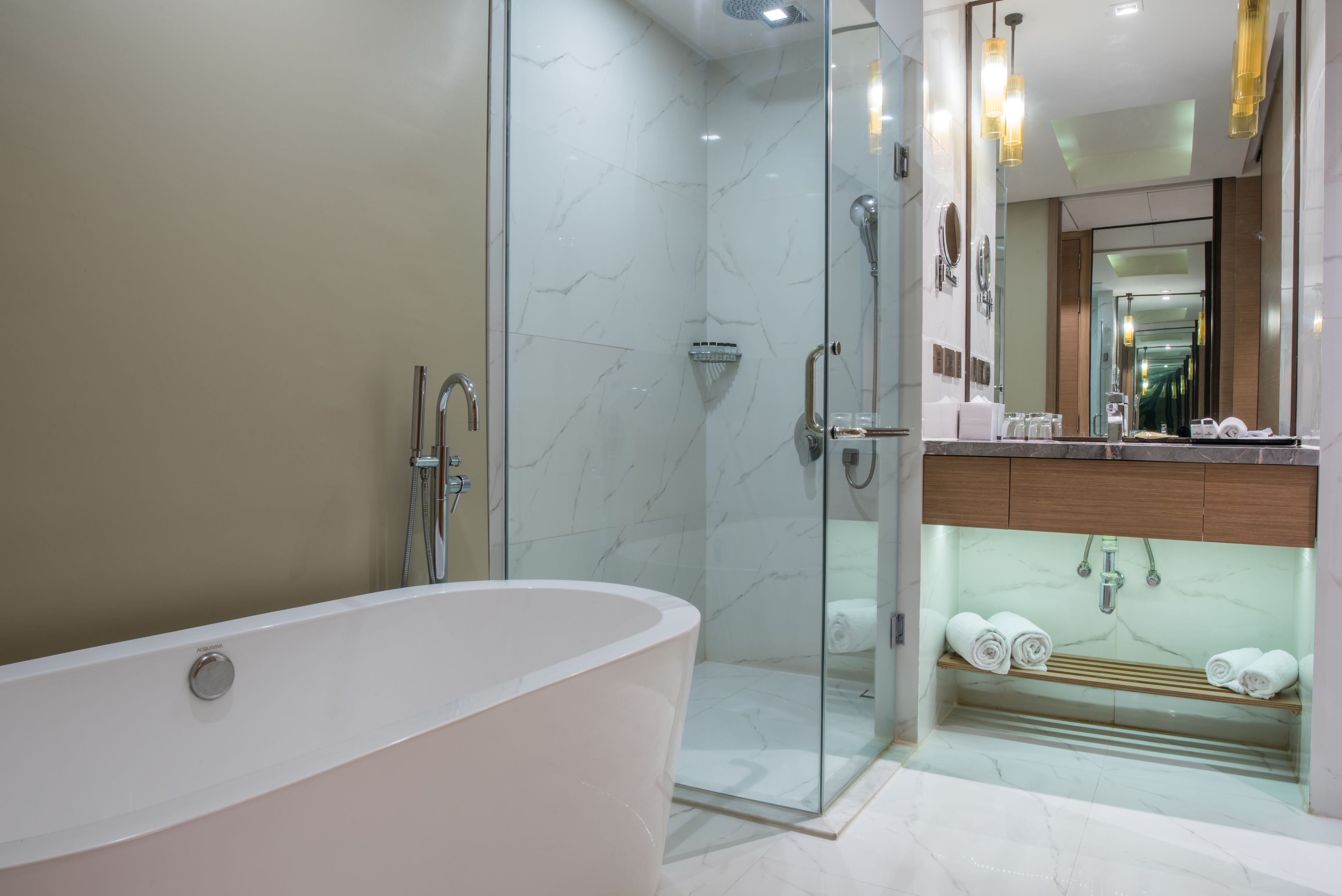Une salle de bain moderne avec une baignoire sur pieds, une douche à parois de verre et un meuble-lavabo doté d’un miroir et d’un porte-serviettes.