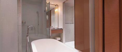 A modern bathroom with a freestanding bathtub, a glass-enclosed shower, and a wooden vanity.