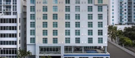 A modern hotel building with multiple floors, large windows, and a visible entrance.