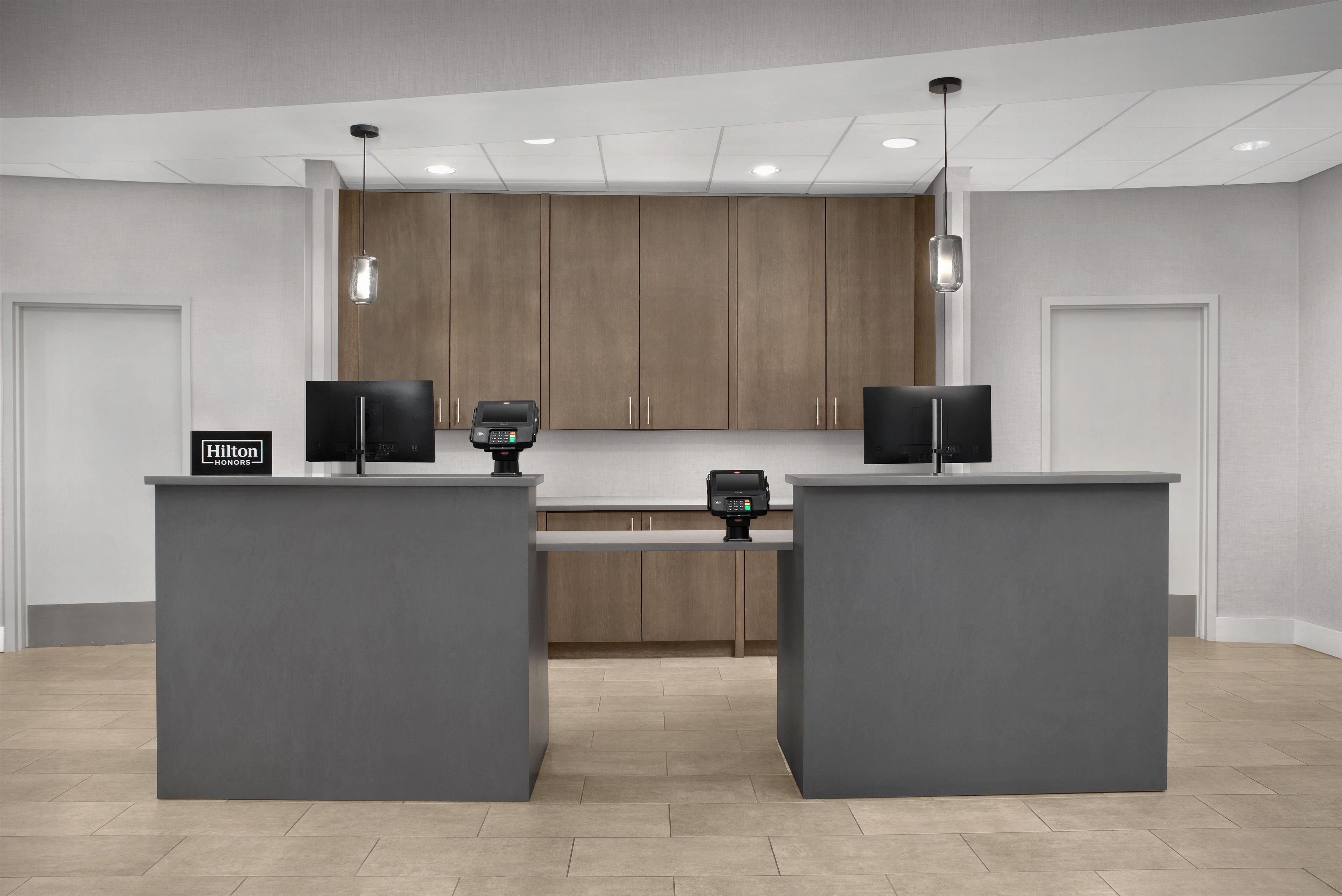 A modern reception desk with a digital display and a sign for Hilton Honors.