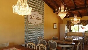 Un comedor con una mesa grande y sillas, candelabros y una pared con un diseño geométrico.