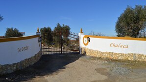 Una entrada cerrada con un muro de piedra y una reja de metal.
