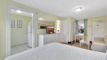 Une chambre à coucher comprenant un lit, une commode, un miroir, un bureau et une chaise.