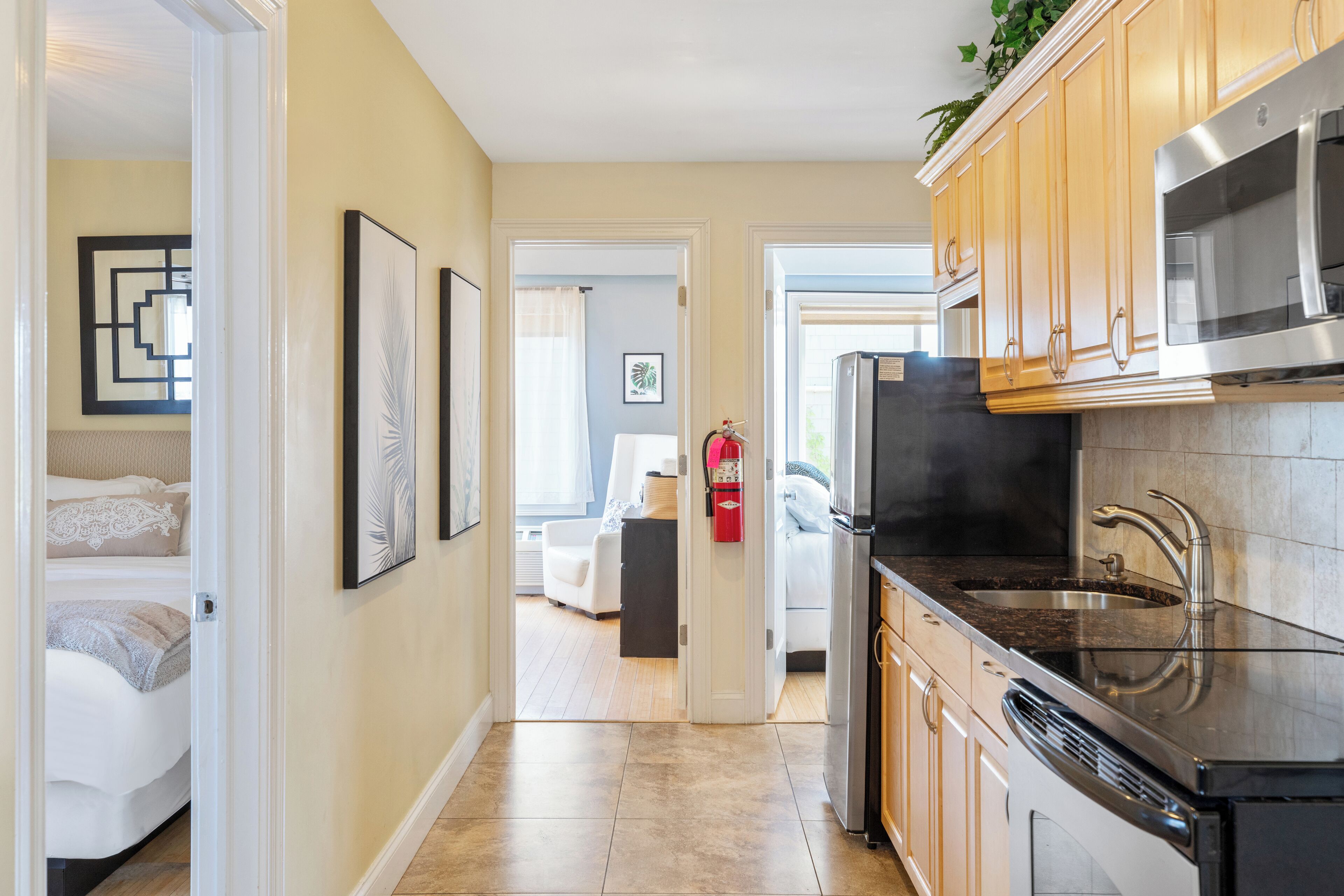 A modern kitchen with stainless steel appliances, wooden cabinets, and a tiled backsplash.