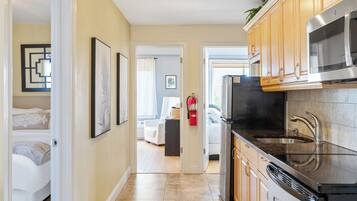 A modern kitchen with stainless steel appliances, wooden cabinets, and a tiled backsplash.