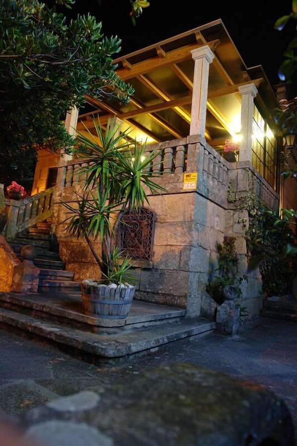 Vista frontal de la propiedad por la tarde o noche