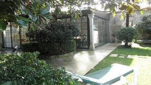 Une cour dotée d’un espace de repos abrité, d’un mur en pierre et d’une pelouse bien entretenue.