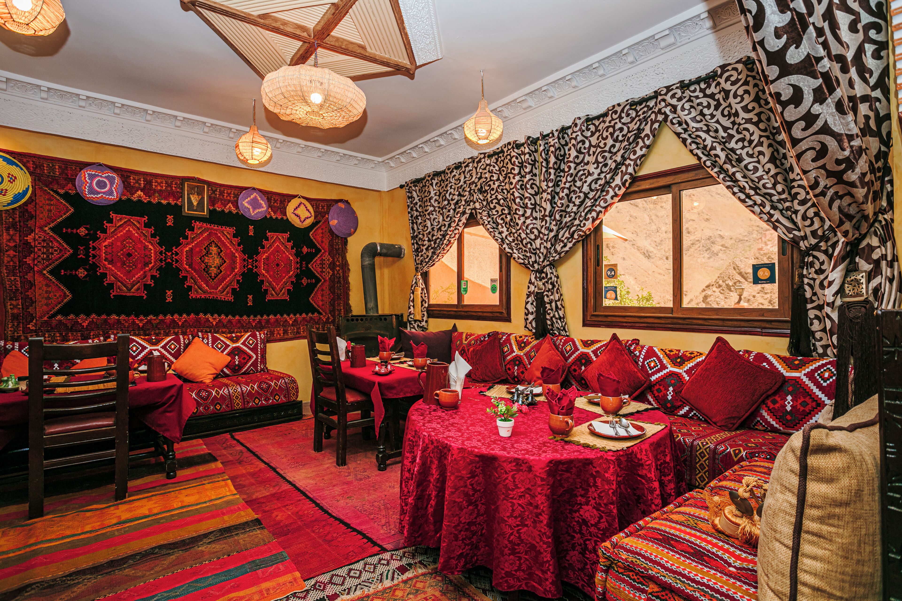 Une pièce de style traditionnel, avec des tapis à motifs, un ensemble de canapés, une table à manger et une fenêtre agrémentée de rideaux.