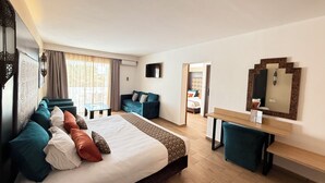 A hotel room with a bed, a desk, a chair, a TV, and a window with curtains.